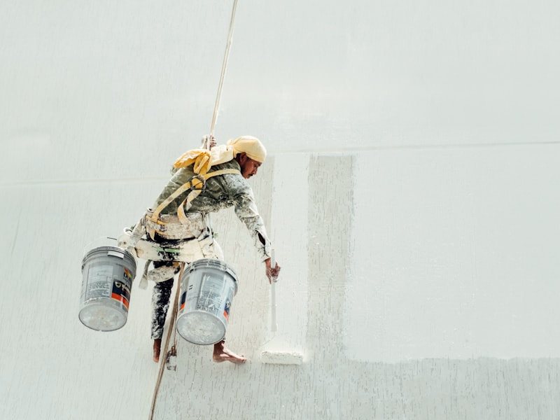 A painter working a large commercial wall from height