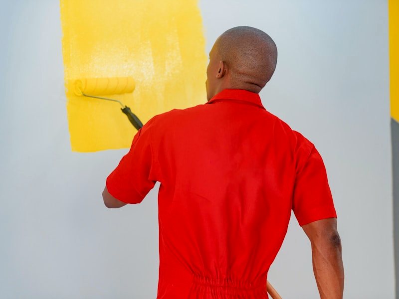 A painter rolling a saturated colour onto an interior wall